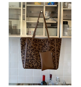 Detail view of brown leopard print tote bag with matching zippered pouch and shoulder straps