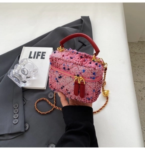 Close-up of mini tweed chain bag featuring pink diamond stitching and gold metal hardware