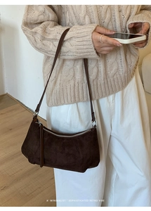 Sac à épaule en daim marron foncé avec fermeture éclair argentée et texture mate