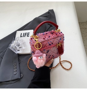 Detail of pink tweed mini bag with red leather handle and plush charm accessory