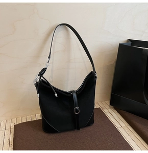 Détail du sac bandoulière noir mat avec bandoulière nouée et maillons de chaîne argentés