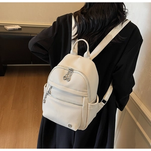 Detailed back view of a white pebble leather backpack with silver zippers and large capacity