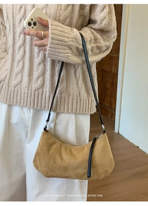 Détail du sac à bandoulière minimaliste en daim jaune avec sangle noire et fermeture éclair