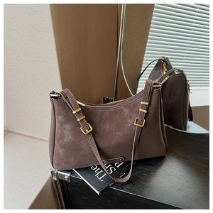 Detail of dark brown frosted leather shoulder bag with vintage gold metal hardware buckles