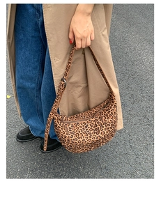 Detail view of leopard print crescent bag with adjustable strap and metallic buckle closure