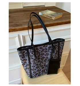 Macro detail of large leopard print tote bag with black leather straps and small coin pouch