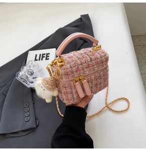 Detail of pink tweed mini bag with gold chain strap and cute sheep plush charm