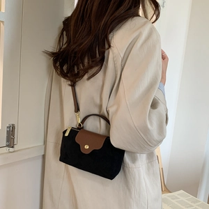 Minimalist faux suede crossbody bag with contrast leather flap and gold buckle on a model