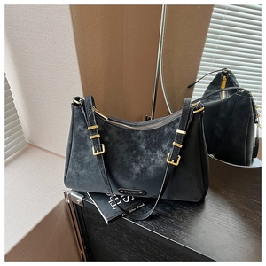 Macro shot of black frosted vintage shoulder bag with golden metal buckle and hardware