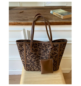 Close-up of leopard print tote bag with suede texture and a matching mini coin purse
