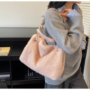 Detail of pink faux fur shoulder bag with gold metal chain and leather strap
