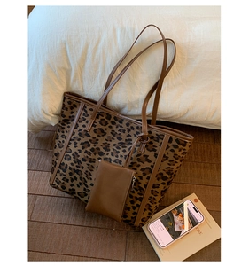 Detail view of the leopard print tote bag with brown straps and matching coin purse