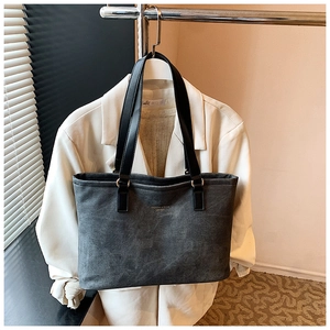 Detail view of dark grey tote bag with fashion lettering and slim black handles