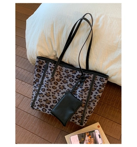 Close-up of leopard print tote bag with black leather straps and detachable pouch