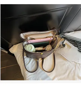Détails de l'intérieur du sac à dos marron montrant l'espace pour tablette et parapluie
