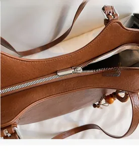 Detail of silver zipper closure and lychee texture on caramel leather tote bag