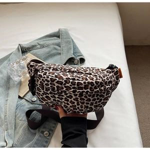 Detail of leopard print crossbody bag with quilted texture and adjustable brown strap