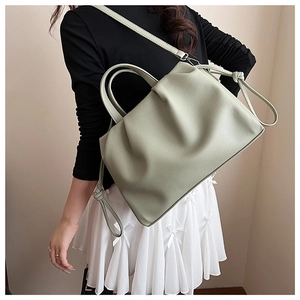 Detailed view of the pleated dumpling shoulder bag in sage green with adjustable strap