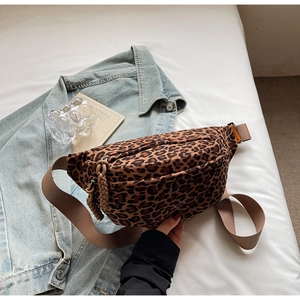 Detail of leopard print crossbody bag with orange woven label and adjustable strap