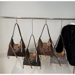 Macro display of leopard print tote bags with leather trim and decorative teddy bear charms
