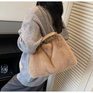 Detail of soft khaki faux fur tote bag with golden metal chain strap and leather handle