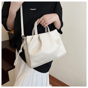 Detail of elegant pleated cream shoulder bag with textured leather and adjustable strap