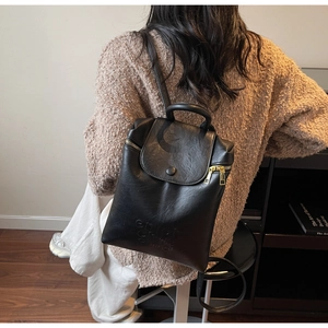 Détail d'un sac à dos en similicuir noir mat avec vue arrière et fermeture éclair en métal