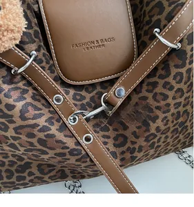 Detailed shot of leopard print tote bag featuring leather pocket and silver metal hardware