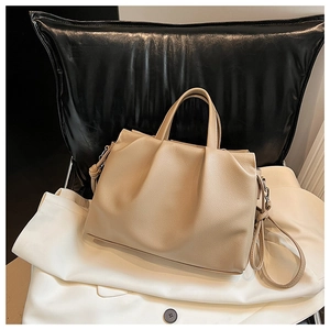 Detail of khaki pleated leather shoulder bag with fine lychee grain and dual handles