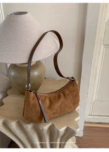 Détail du sac à bandoulière en daim marron vintage avec fermeture éclair en métal