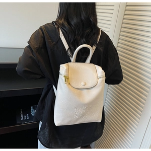 Détail d'un sac à dos en similicuir beige avec logo embossé et fermeture éclair dorée