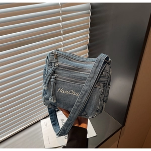 Detail of vintage denim crossbody bag with HanCha embroidery and multi-layer zippers