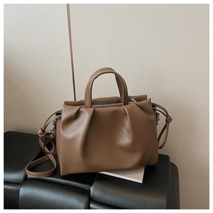 Close-up of brown pebbled leather texture and elegant pleat design on this handbag