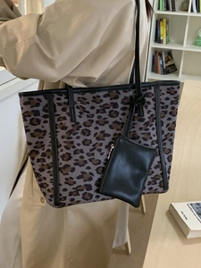Large leopard print tote bag with black strap and mini pouch shown on a model