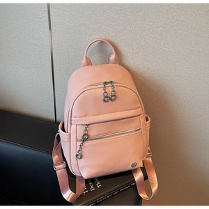 Detailed shot of pink faux leather backpack with litchi texture and silver chain