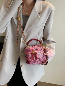 Pink tweed quilted crossbody bag with gold chain and plush charm shown on a model