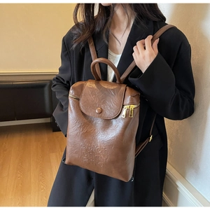 Détail du sac à dos vintage marron avec logo embossé enjoh chin 2nd sur le cuir souple