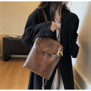 Sac à dos vintage en similicuir marron avec logo embossé et fermeture à rabat chic