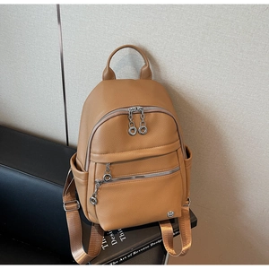 Detail of camel lychee leather backpack with multiple zip pockets and side pouches