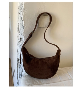 Dettaglio ravvicinato della borsa a mezzaluna in camoscio marrone con texture retrò