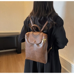 Vue de dos d'un mannequin portant un sac à dos vintage en cuir marron gaufré