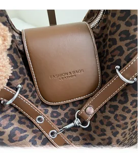 Close-up of leopard print fabric with brown leather flap and silver buckle detail