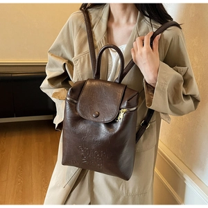 Détail du sac à dos vintage en cuir marron foncé avec logo onon chin en relief