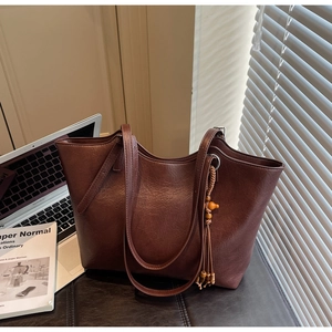 Detail of vintage brown tote bag with decorative tassel and elegant leather texture