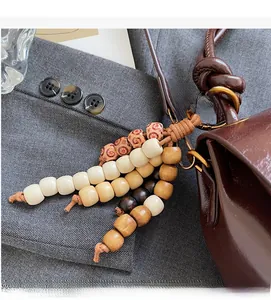 Close-up of ethnic style handcrafted wooden beads pendant on a dark brown leather handbag