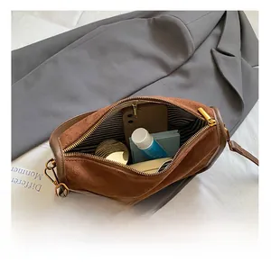 Detailed interior of dark brown suede bag showing striped lining and storage capacity