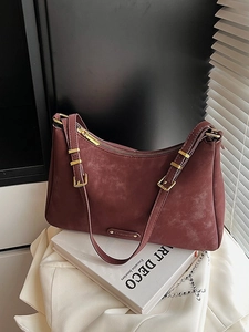 Retro matte burgundy crossbody bag with gold hardware and adjustable strap on white book