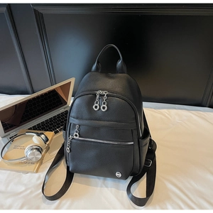Close-up of black lychee grain leather backpack with silver metal zippers and hardware