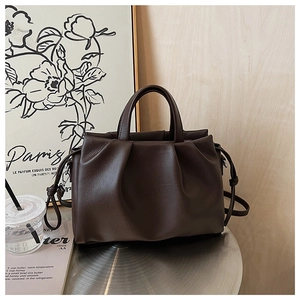 Detail view of dark brown tote bag with wrinkled texture and litchi grain faux leather