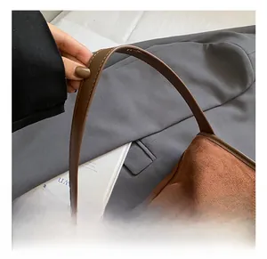 Detailed shot of brown faux suede shoulder bag with premium metal zipper and leather strap